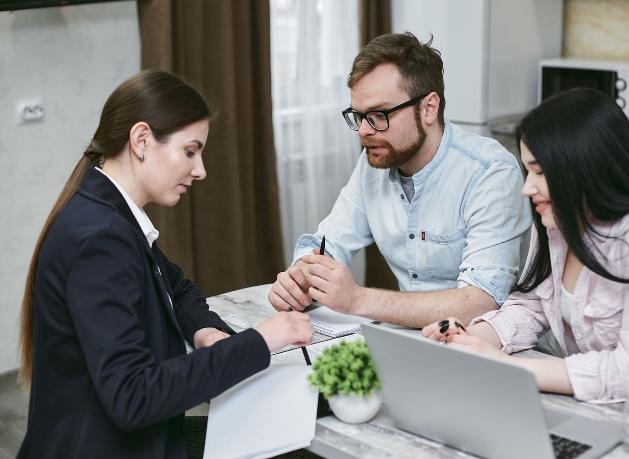 about-us A couple discusses financial documents with their advisor, highlighting investment strategies.